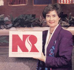 Former NINR Director Dr. Ada Sue Hinshaw holding NINR's plaque for Institute status at NIH.